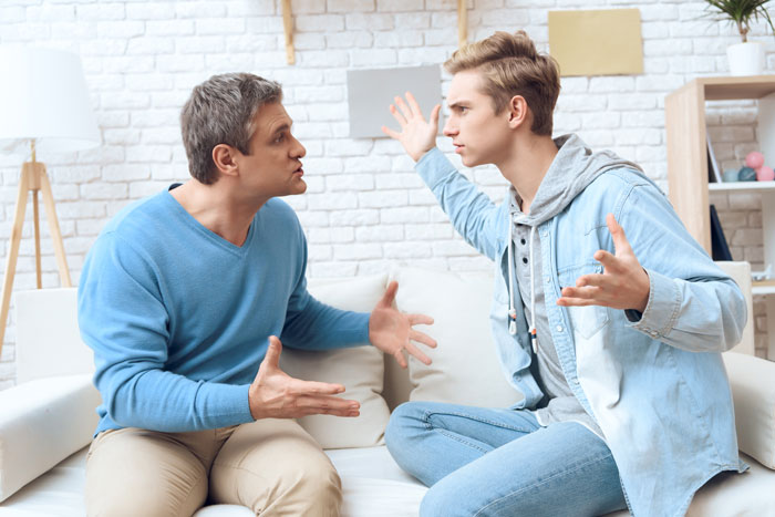 Teenager argues with man in living room, expressing frustration after years of unpaid babysitting and lack of respect.