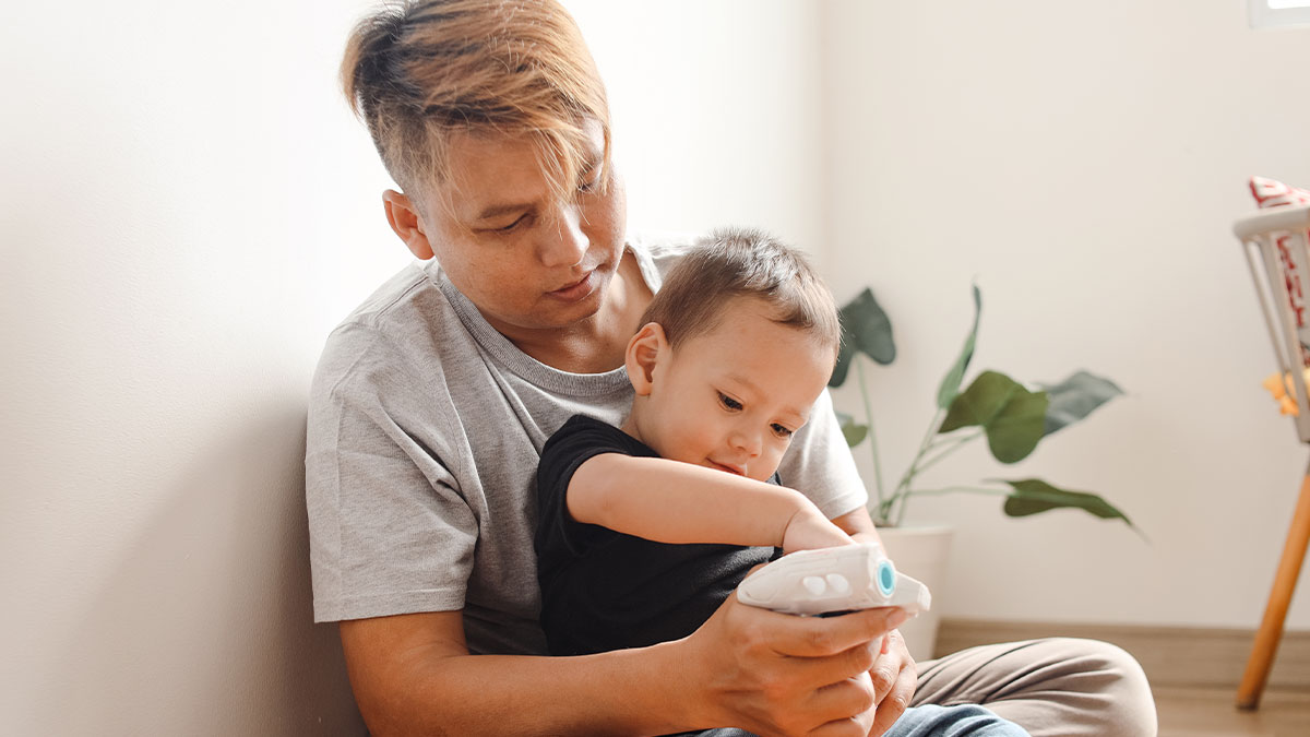 Teen babysitter holding toddler playing with a toy in a bright room, reflecting years of unpaid childcare and lack of respect.