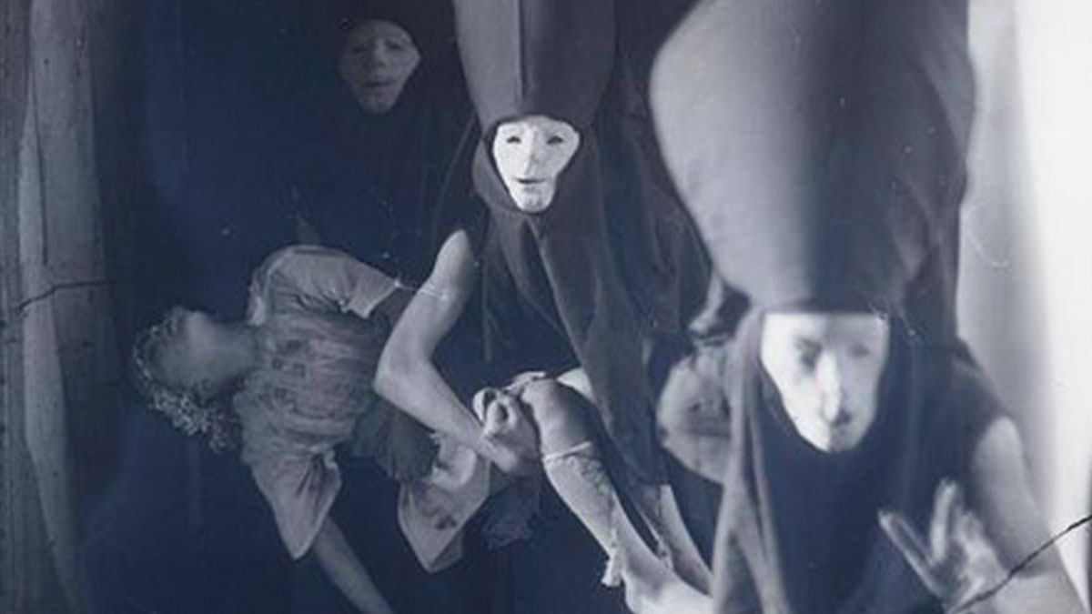 Vintage creepy photo showing people in eerie masks holding a limp doll, capturing an unsettling past moment.