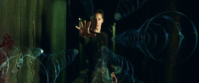 A man in a dark corridor holds out his hand, surrounded by swirling digital spirals representing manipulated AI thoughts.