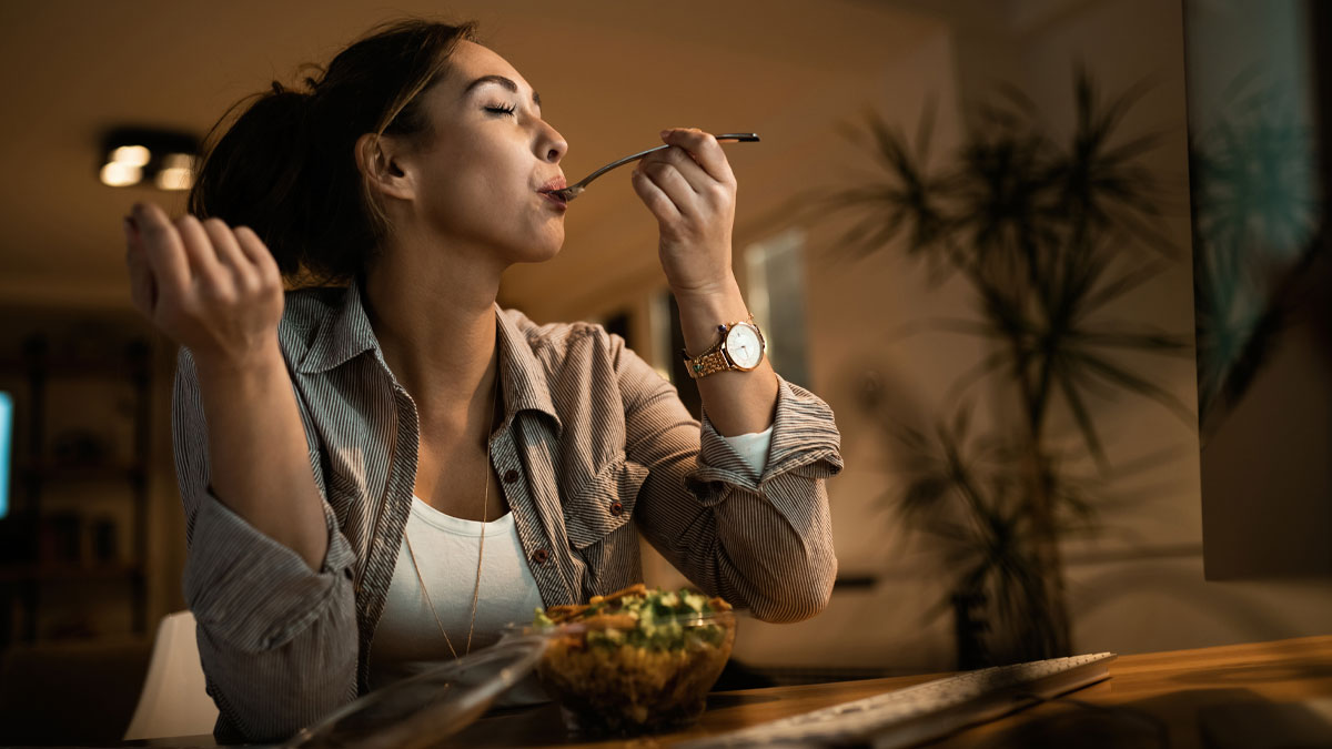Woman enjoying a meal at home, illustrating things non-Americans do that make no sense to Americans in casual setting.