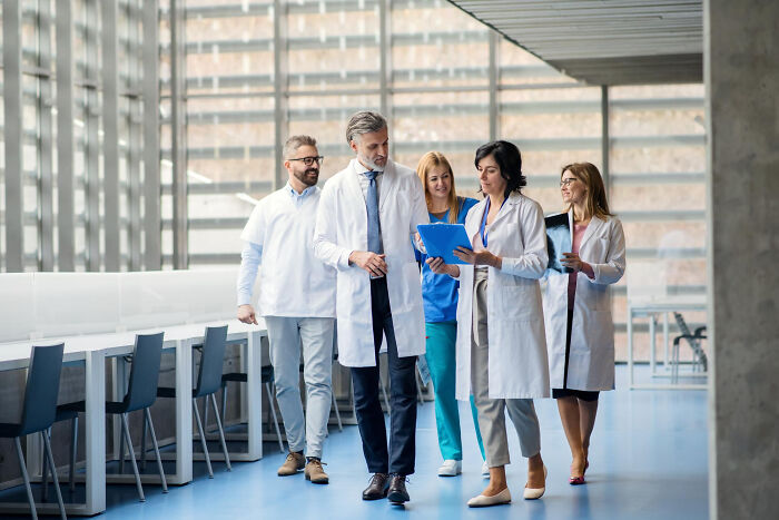 Medical professionals walking in a modern hospital corridor, reflecting on values from the good old days slowly disappearing.