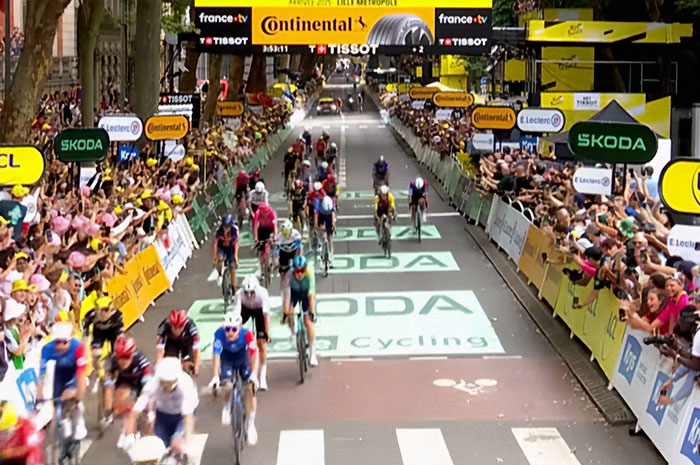 Cyclists racing at Tour De France finish line with crowds standing on graves for better view causing outrage. Cyclists racing at Tour De France finish line with crowds standing on graves for better view causing outrage.