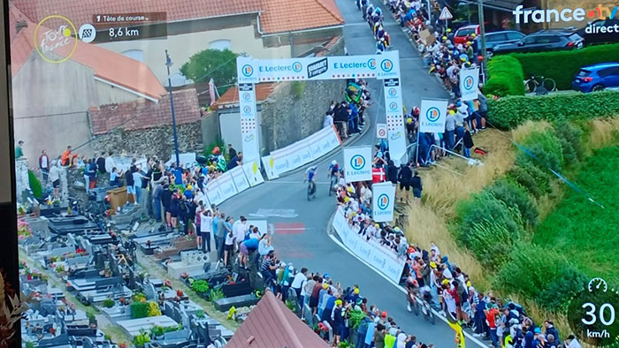 Tour de France fans standing on graves for better view near race route, sparking outrage among spectators and community. Tour de France fans standing on graves for better view near race route, sparking outrage among spectators and community.