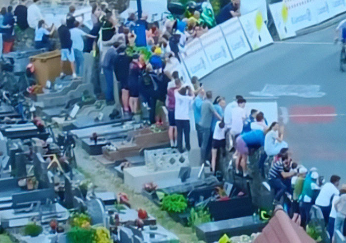 Tour De France fans standing on graves to get a better view, sparking outrage among spectators and communities. Tour De France fans standing on graves to get a better view, sparking outrage among spectators and communities.