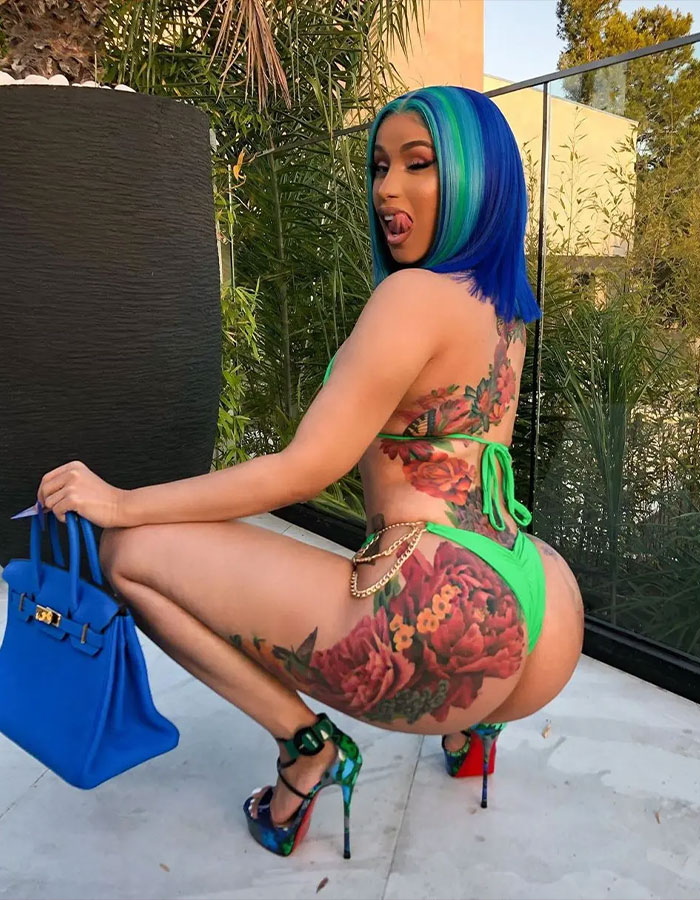 Cardi B squats outdoors showing colorful tramp stamp tattoo and floral body art, wearing green bikini and high heels. Cardi B squats outdoors showing colorful tramp stamp tattoo and floral body art, wearing green bikini and high heels.