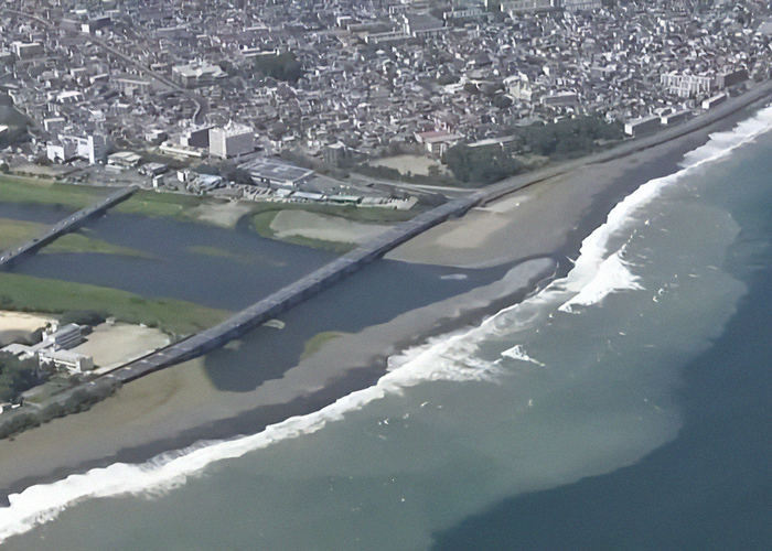 Aerial view of first tsunami waves slamming into coastal areas of Japan following a mega earthquake warning. Aerial view of first tsunami waves slamming into coastal areas of Japan following a mega earthquake warning.