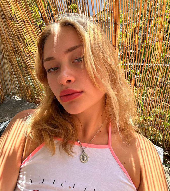 Young female model with blonde hair posing outdoors with bamboo fence background, related to broken limbs and spine case in Dubai. Young female model with blonde hair posing outdoors with bamboo fence background, related to broken limbs and spine case in Dubai.