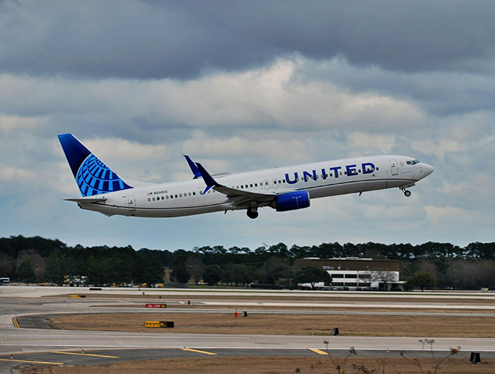 United Airlines plane taking off under cloudy sky, related to trafficking accusations by airline crew. United Airlines plane taking off under cloudy sky, related to trafficking accusations by airline crew.