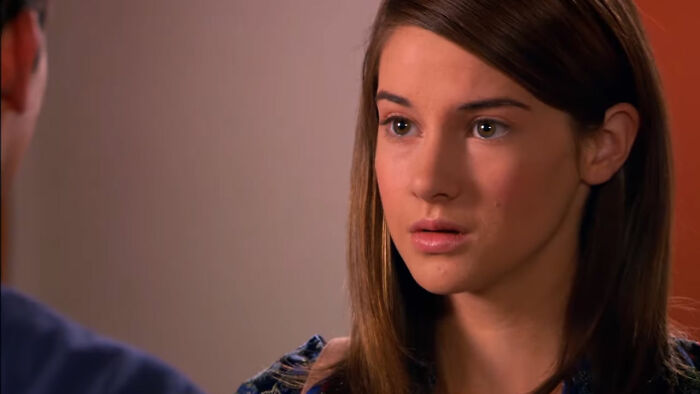 Young woman with brown hair looking concerned in a scene from shows with characters hard to love.