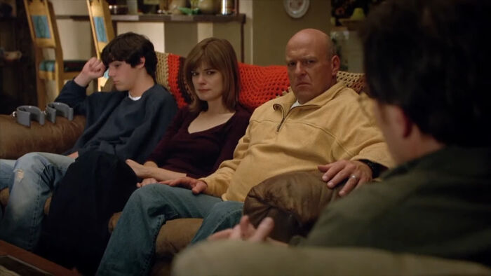A tense family scene from a TV show featuring characters that are very hard to love sitting on a couch.