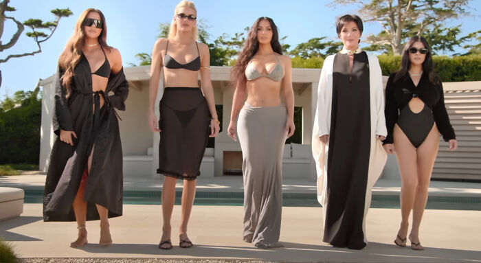 Group of five women standing confidently poolside wearing stylish swimsuits and cover-ups, representing hard to love characters in shows.