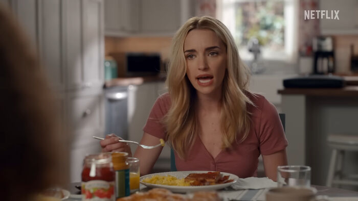 Woman eating breakfast in a kitchen scene from a Netflix show featuring hard to love characters.