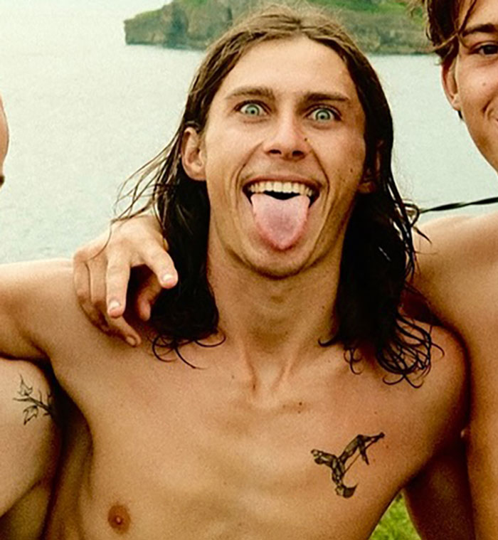 Young daredevil shirtless with long hair sticking out tongue, possibly before attempting record-breaking dive stunt. Young daredevil shirtless with long hair sticking out tongue, possibly before attempting record-breaking dive stunt.