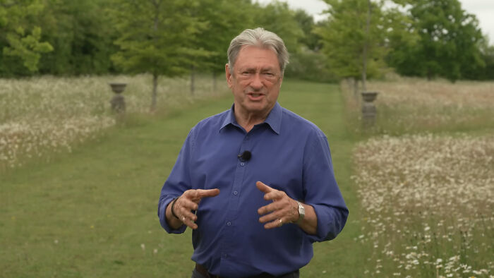 Older man in blue shirt speaking outdoors in a garden, relating to celebrities many people love but can’t stand.