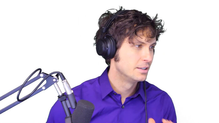 Person wearing headphones and purple shirt speaking into a microphone, discussing people share unsubscribed YouTubers.