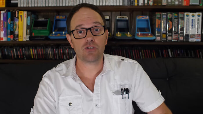 A man wearing glasses and a white shirt shares insights about people who share unsubscribed YouTubers in a casual setting.