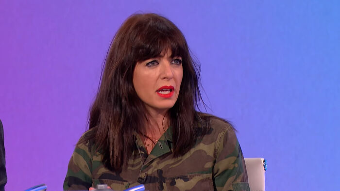 Woman in a camouflage shirt speaking on a talk show about celebrities many people love but just can't stand.