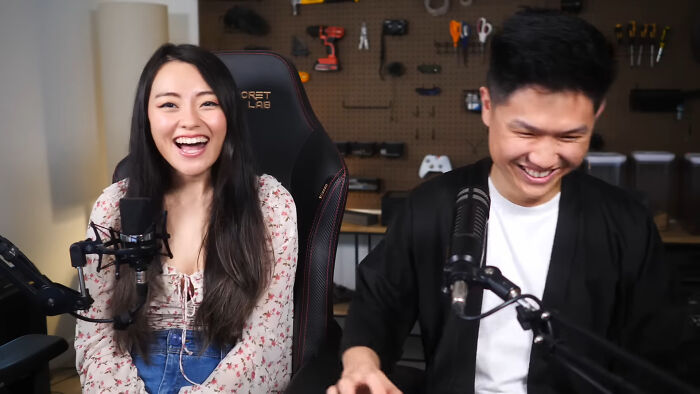Two people in a recording setup smiling and laughing while discussing content for unsubscribed YouTubers.