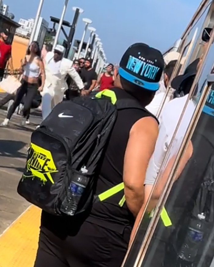 Men on subway platform delivering vigilante justice after a brute attacked a woman, crowd reacting in the background. Men on subway platform delivering vigilante justice after a brute attacked a woman, crowd reacting in the background.