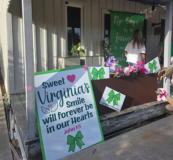 Memorial signs and flowers honoring a young girl after Camp Mystic tragedy with green ribbon awareness symbols. Memorial signs and flowers honoring a young girl after Camp Mystic tragedy with green ribbon awareness symbols.