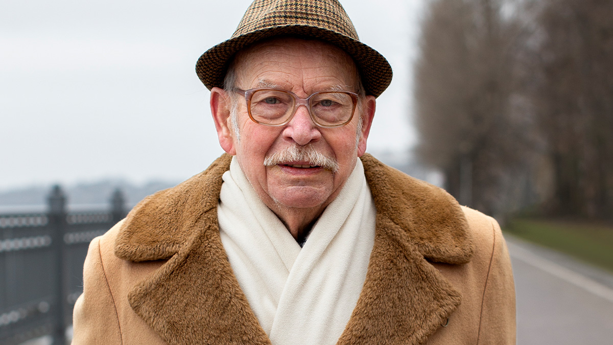 Elderly man wearing a brown coat and hat outdoors, representing a grandfather who escaped North Korea life experiences.
