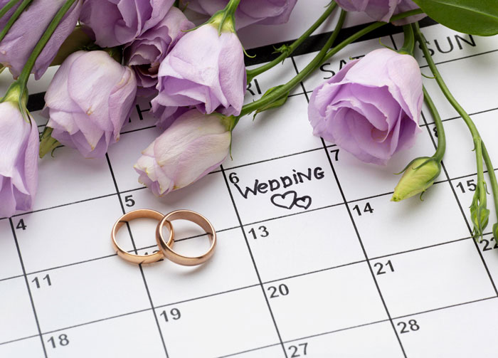 Wedding marked on calendar with two rings and purple flowers symbolizing bride’s protests to change caterer ignored. Wedding marked on calendar with two rings and purple flowers symbolizing bride’s protests to change caterer ignored.