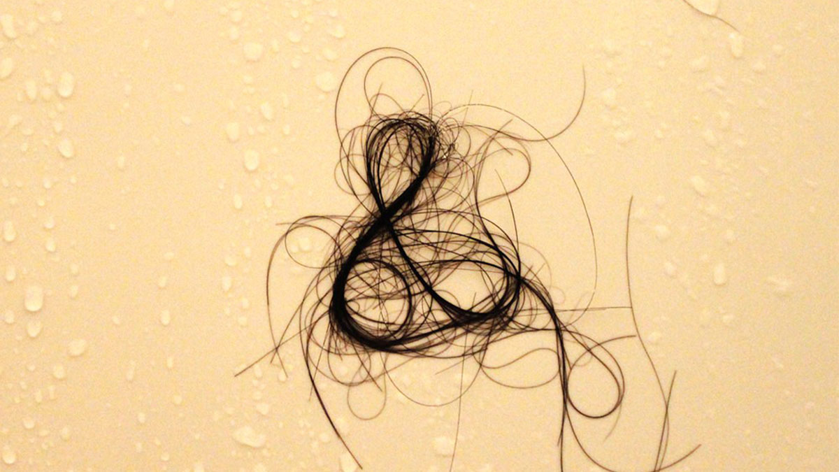 Clump of tangled hair on a wet surface representing a rare phobia related to hair loss or shedding fears.
