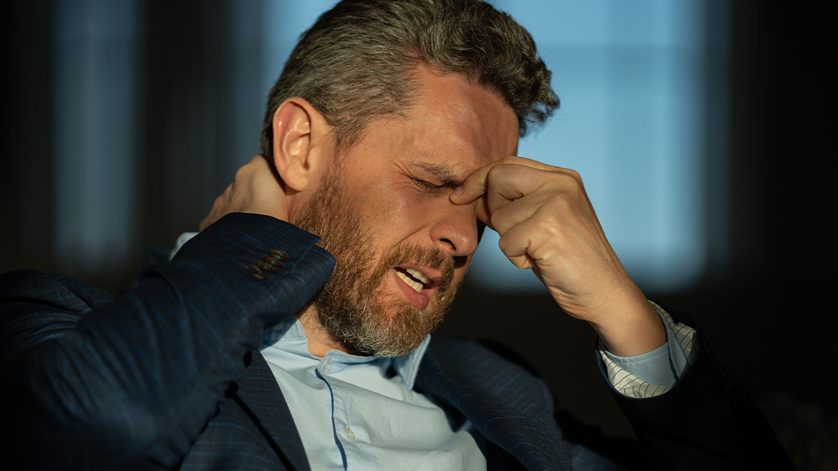 Man in a suit showing distress and frustration, symbolizing emotions in a womanu2019s dream trip alone to find herself.