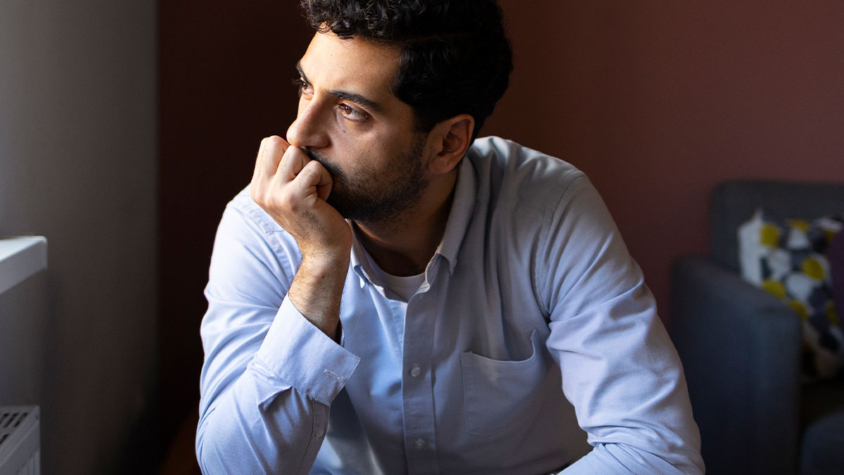 Man looking worried and deep in thought, reflecting on husband feels sick after realizing who their son is named after.