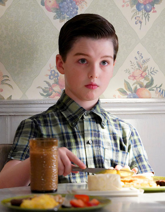 Young Sheldon child star sitting at breakfast table with plaid shirt, fans remarking he looks like Tom Cruise after growing up Young Sheldon child star sitting at breakfast table with plaid shirt, fans remarking he looks like Tom Cruise after growing up