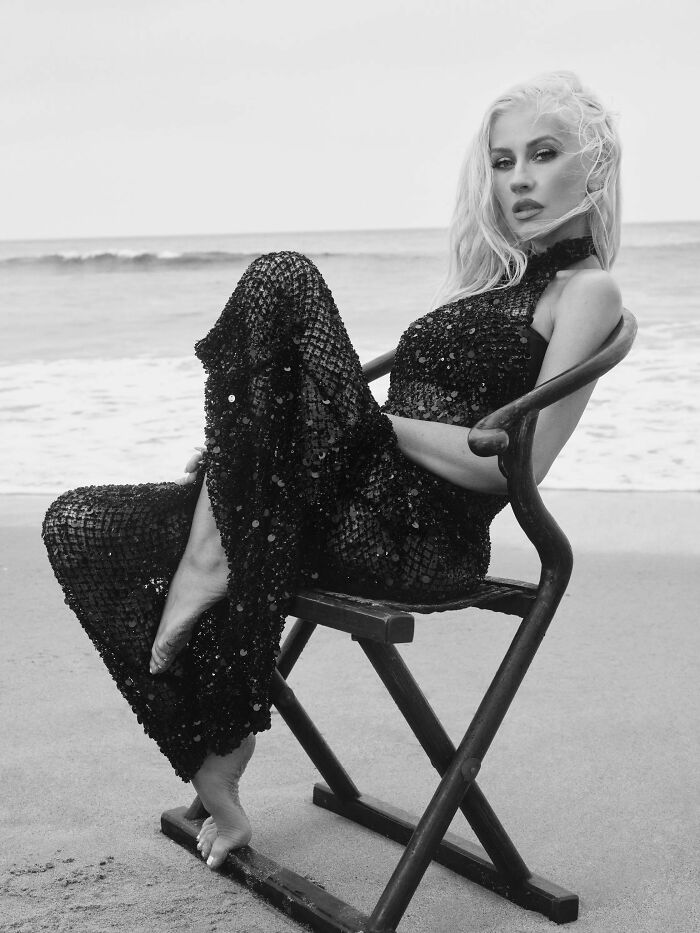 Christina Aguilera in a black sequined dress sitting on a chair by the beach amid Ozempic overuse diet speculation. Christina Aguilera in a black sequined dress sitting on a chair by the beach amid Ozempic overuse diet speculation.