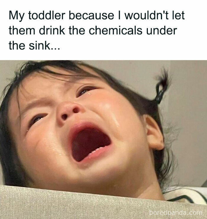 Crying toddler upset after being denied chemicals under the sink, illustrating relatable cool mom parenting moments.