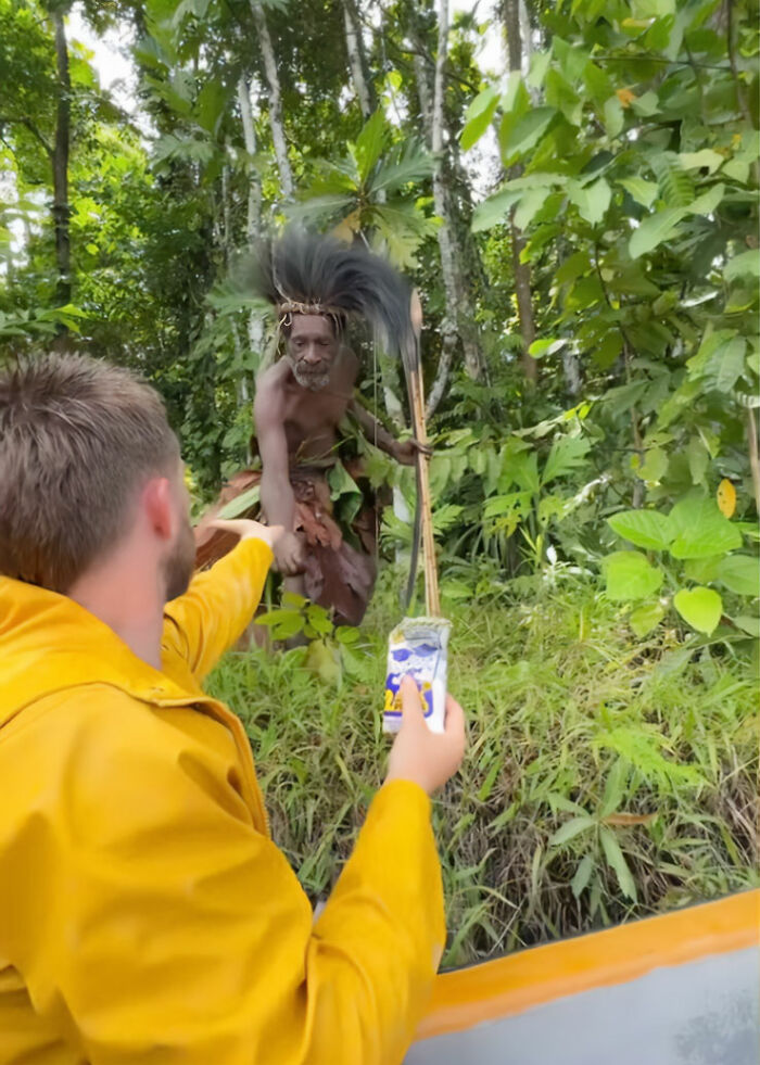 Man filming indigenous tribe member in forest, sparking outrage over viral TikTok stunt and cultural sensitivity concerns. Man filming indigenous tribe member in forest, sparking outrage over viral TikTok stunt and cultural sensitivity concerns.