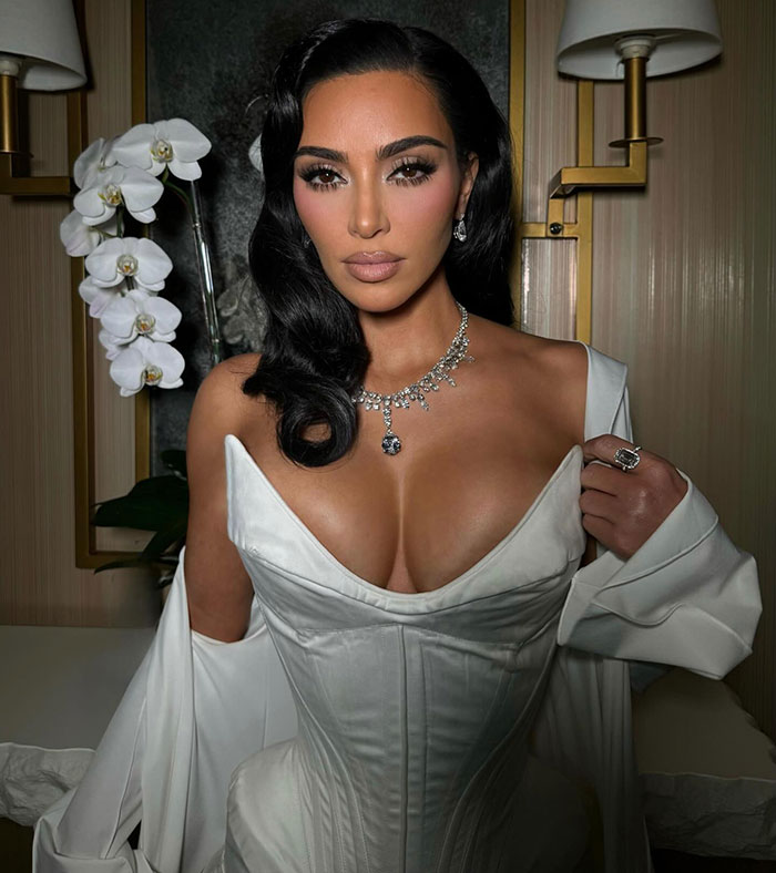 Kim Kardashian posing in a white corset dress with glamorous jewelry in her new Skims campaign that looks like diaper style. Kim Kardashian posing in a white corset dress with glamorous jewelry in her new Skims campaign that looks like diaper style.