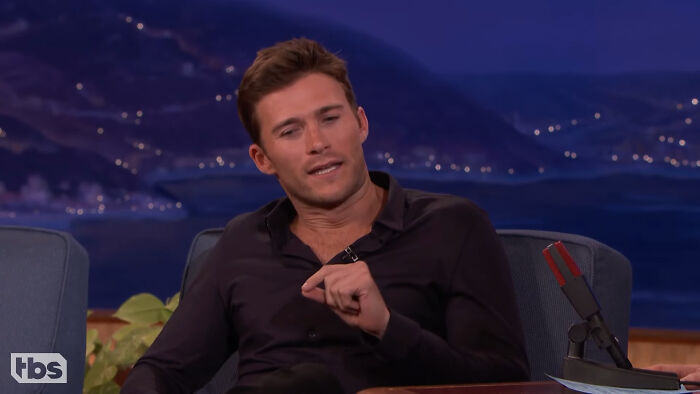 Young male celebrity guest wearing a black shirt, discussing Hollywood celebrities and their attempts to become leading A-listers.
