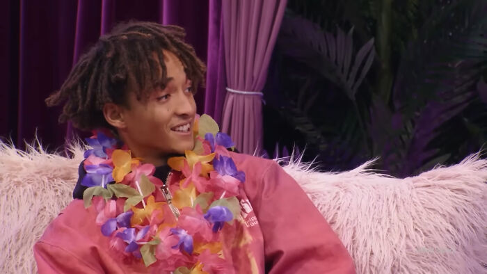 Young celebrity wearing a colorful flower lei and pink sweatshirt, representing Hollywood actors who struggled as leading A-listers.