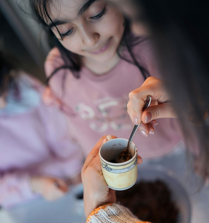 Woman proving husband wrong by confidently preparing a coffee mug, showing independence and capability.