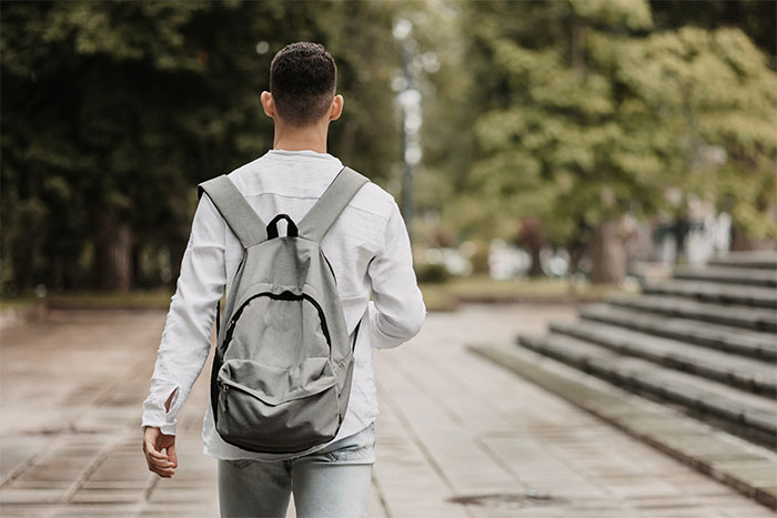 Young man walking away outdoors, symbolizing anger and breakup after woman threw away his dinner.