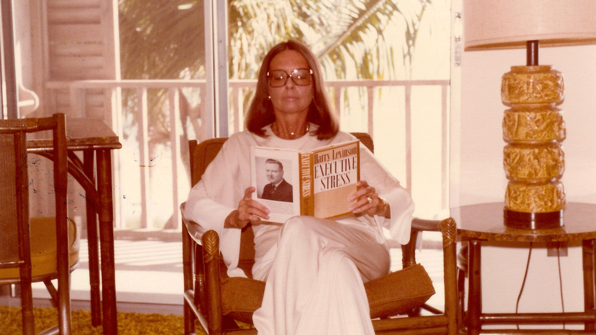 Woman in Florida reading a book indoors, showcasing 1970s style while breaking barriers in the era.