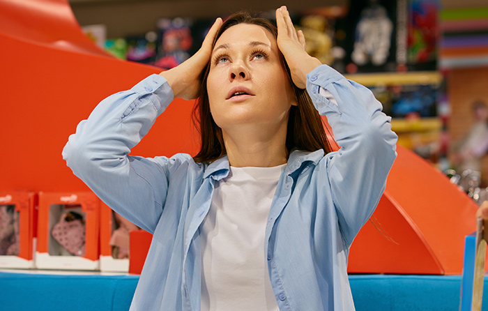A stressed woman at work looks upward, reacting to a manager calling her useless in a challenging office moment. A stressed woman at work looks upward, reacting to a manager calling her useless in a challenging office moment.