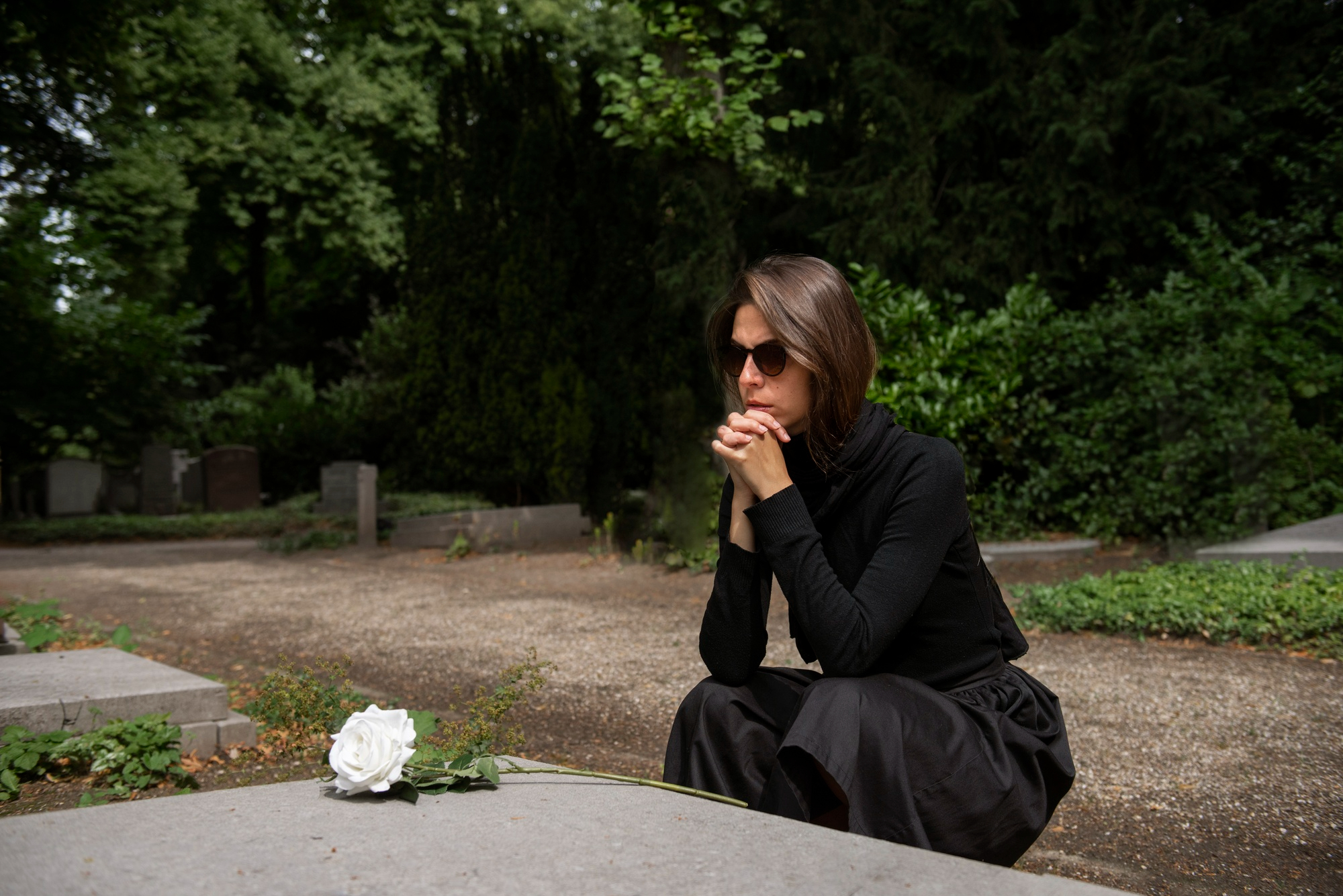 Woman in black mourning attire at a gravesite, reflecting on widow and stepkids feeling hurt and abandoned. Woman in black mourning attire at a gravesite, reflecting on widow and stepkids feeling hurt and abandoned.