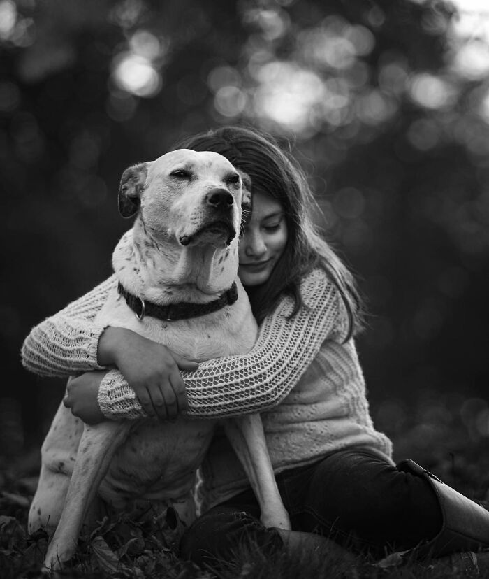 Couple sharing a tender moment with their dog, capturing touching final moments between pets and their humans outdoors.