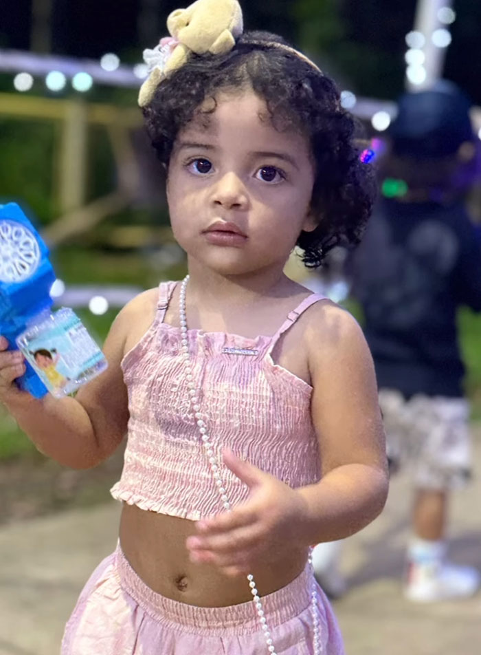 2-year-old child holding a toy outdoors, highlighting the tragic incident involving drowning while dad is streaming. 2-year-old child holding a toy outdoors, highlighting the tragic incident involving drowning while dad is streaming.