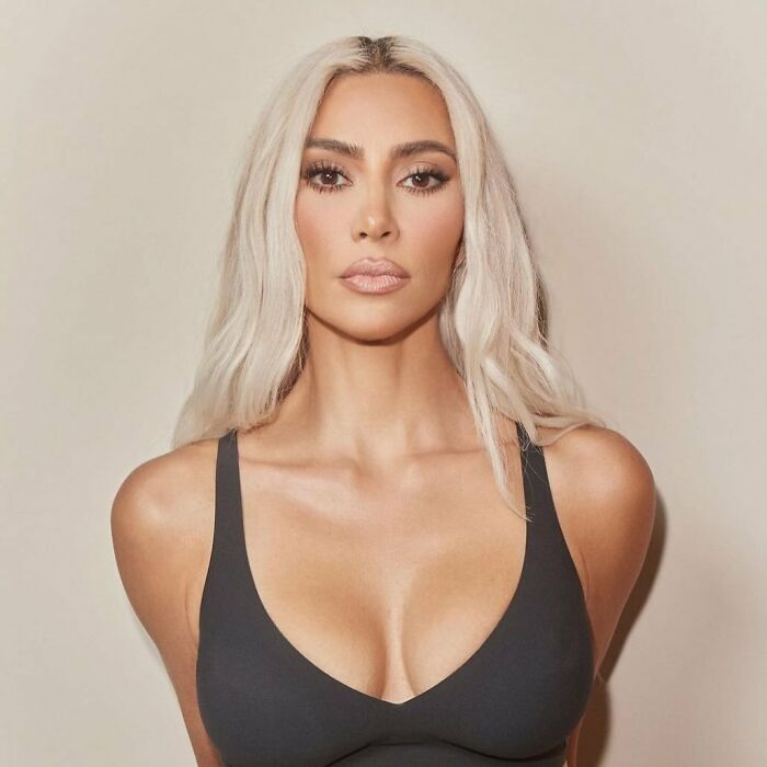 Kim Kardashian with platinum blonde hair, wearing a black top, promoting a viral beauty product in a studio setting. Kim Kardashian with platinum blonde hair, wearing a black top, promoting a viral beauty product in a studio setting.