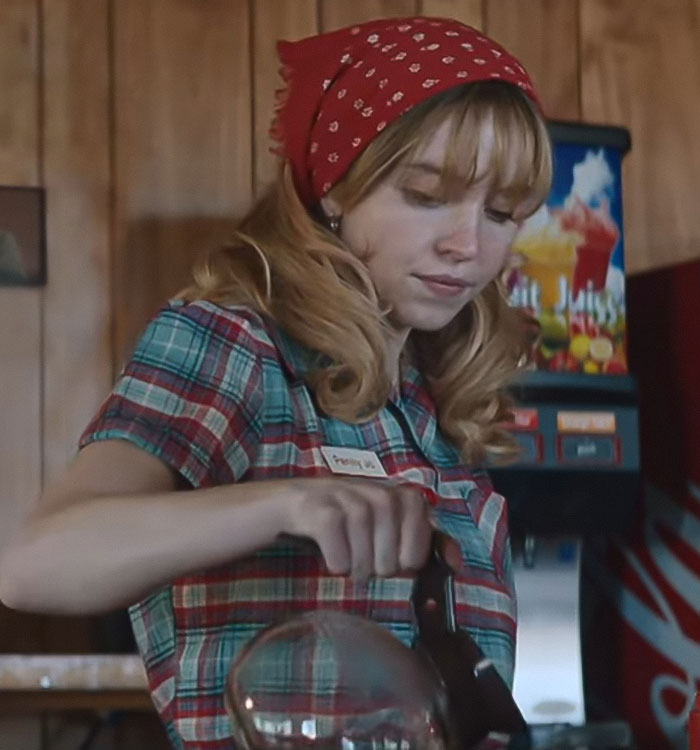 Sydney Sweeney wearing red bandana and plaid shirt, pouring coffee in a retro diner setting amid social media reactions. Sydney Sweeney wearing red bandana and plaid shirt, pouring coffee in a retro diner setting amid social media reactions.