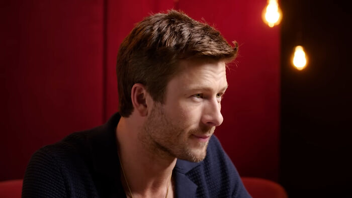 Close-up of a male celebrity in a dark jacket against a red backdrop, illustrating celebrities Hollywood tried to make leading A-listers.