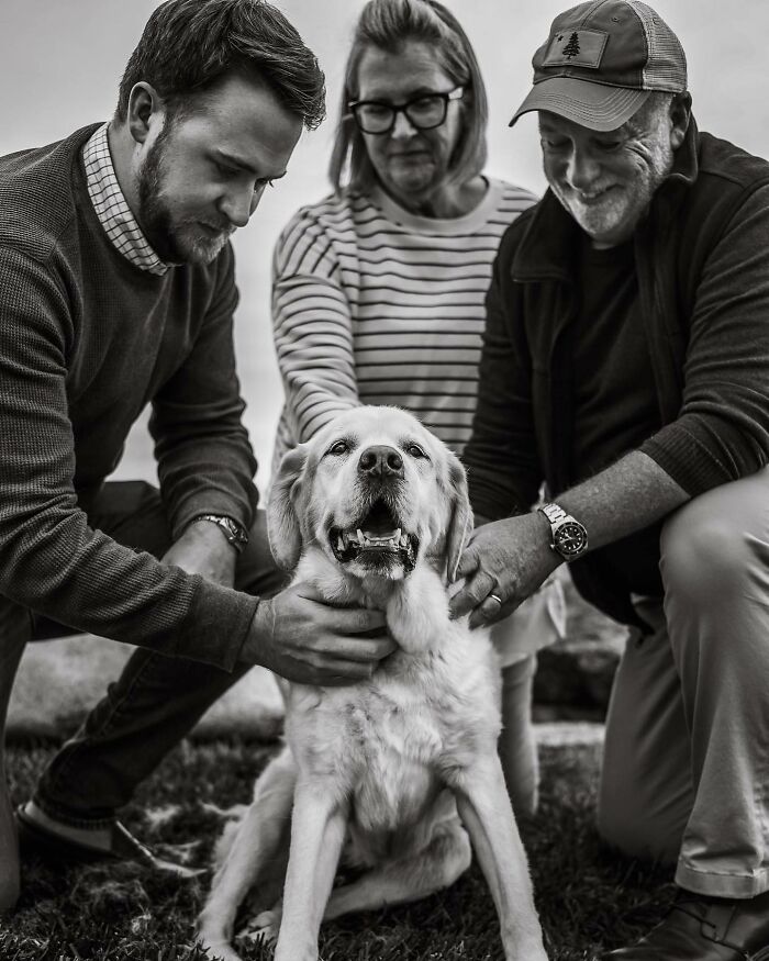 Man tenderly kissing his dog, capturing touching final moments between pets and their humans in black and white.