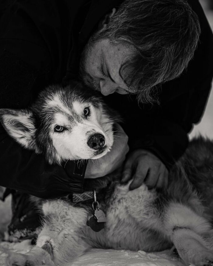 Man lovingly holding and touching noses with his dog, capturing a touching moment between pets and their humans.