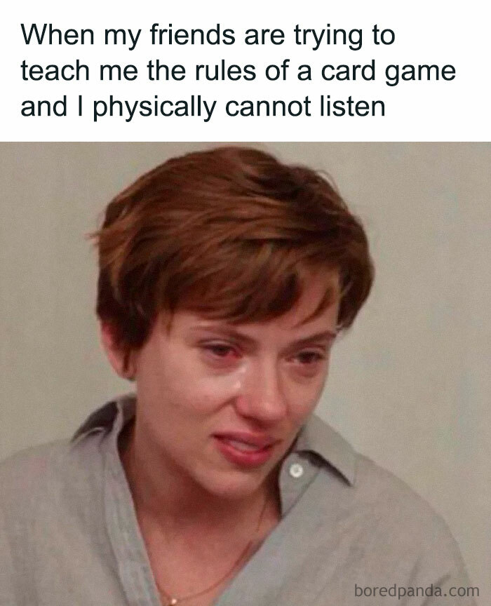 Woman with short hair struggling to listen while friends teach card game, humor related to friendship memes and relatable moments